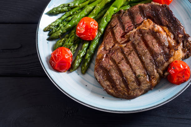istock Grilled beef steak ribeye with cherry tomatoes and asparagus 1151678473