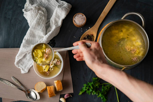 istock chefs hand pour fresh hot soup in a white empty bowl, food preparations 1151678714