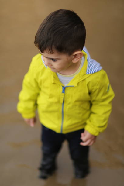 istock Children Playing in Rain Puddle 1151680506