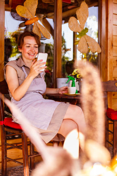 istock Florist looking at mobile phone while enjoying coffee 1151682977