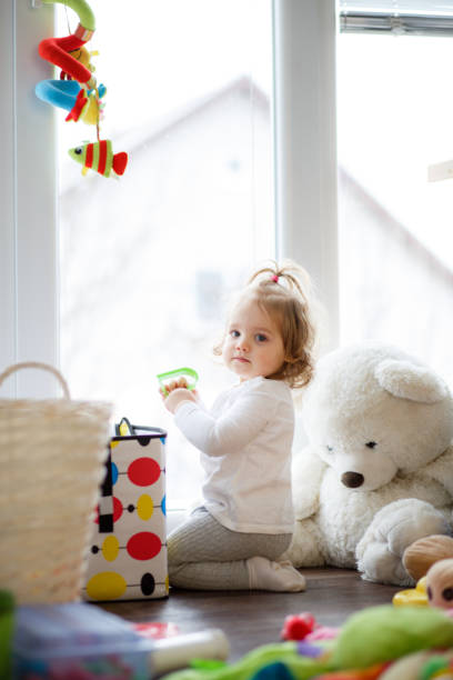 istock Baby girl playing next to a window 1151683706