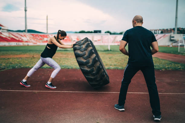istock Woman exercising with a instructor on the running track 1151689112