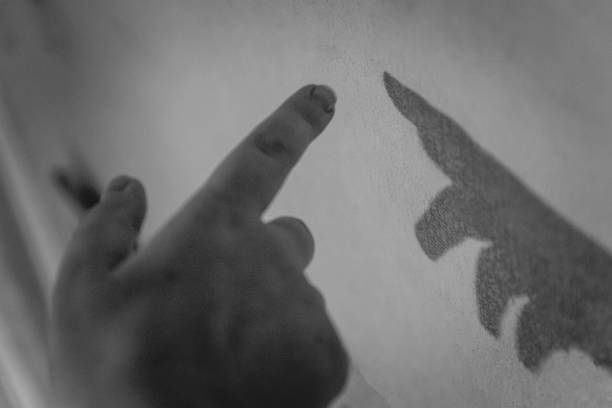 istock Hand and her shadow on the wall. Black and white. Monochrome 1151689792