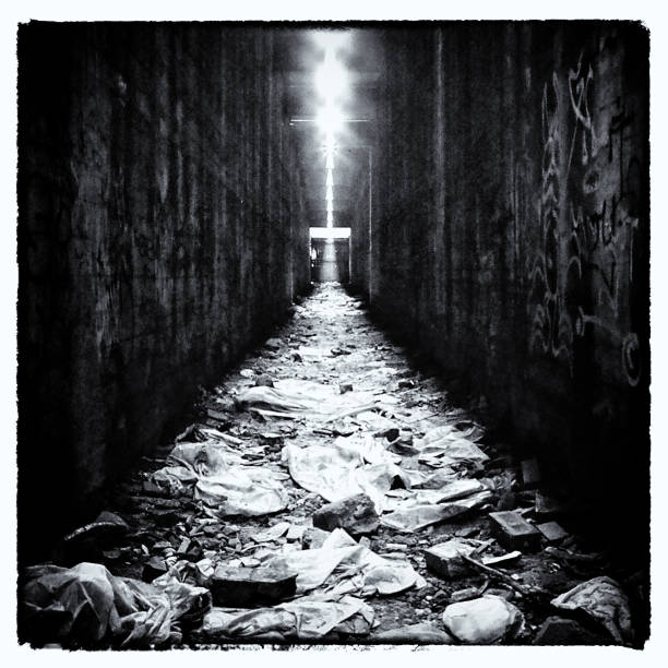 Tunnel with cross shape in distance with rubbish in the foreground.