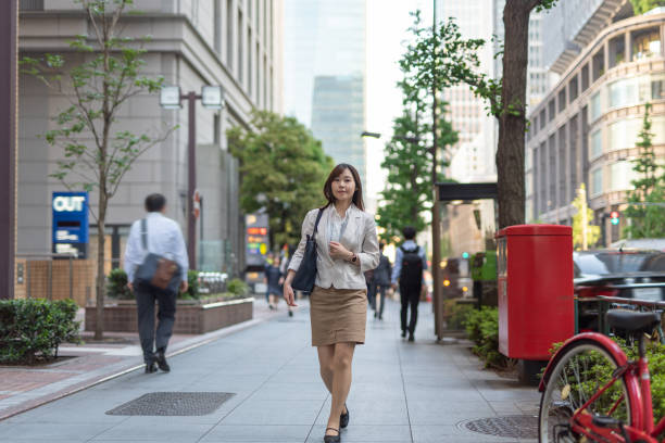 通りを歩いているビジネスウーマン - オフィス街　日本 ストックフォトと画像