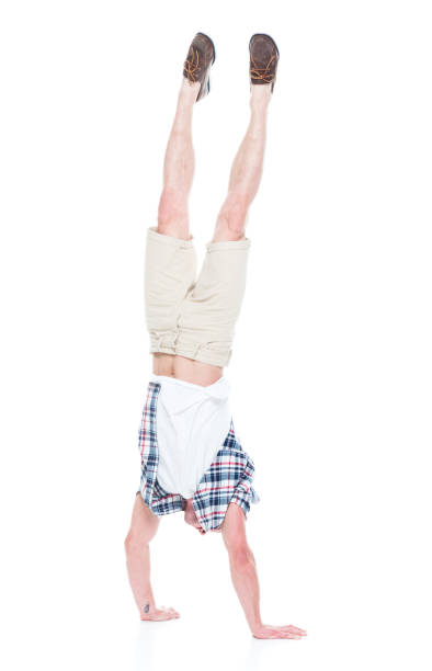 istock Handsome man in shirt and shorts is doing a handstand 1151708390