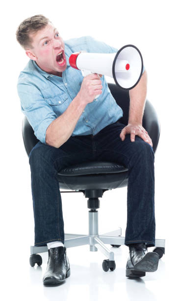 istock Man sitting and being angry with a megaphone 1151716717