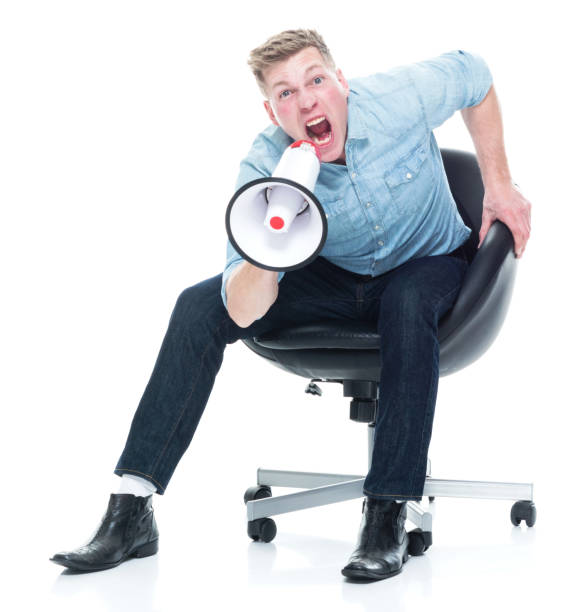 istock Man sitting and being angry with a megaphone 1151716724