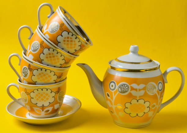 노란색 배경에 복고풍 컵과 찻주전자의 스택. - old fashioned tea cup victorian style beauty 뉴스 사진 이미지