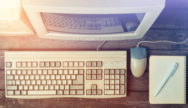istock Retro stationary computer on a rustic wooden table, vintage workspace, top view, flat lay 1151730157