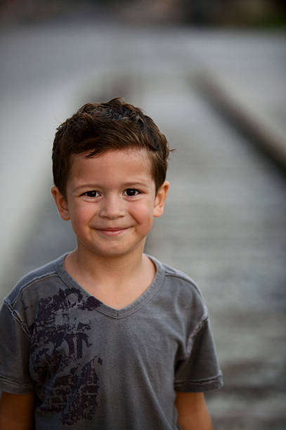little male child boy playing near railway walking on railroad tracks