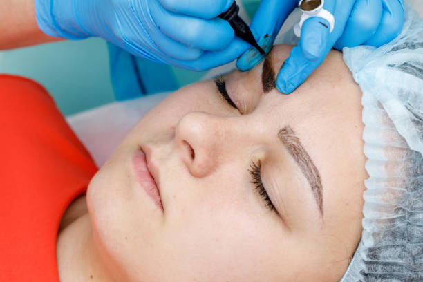 istock Permanent makeup, tattooing of eyebrows. Cosmetologist applying make up 1151734488