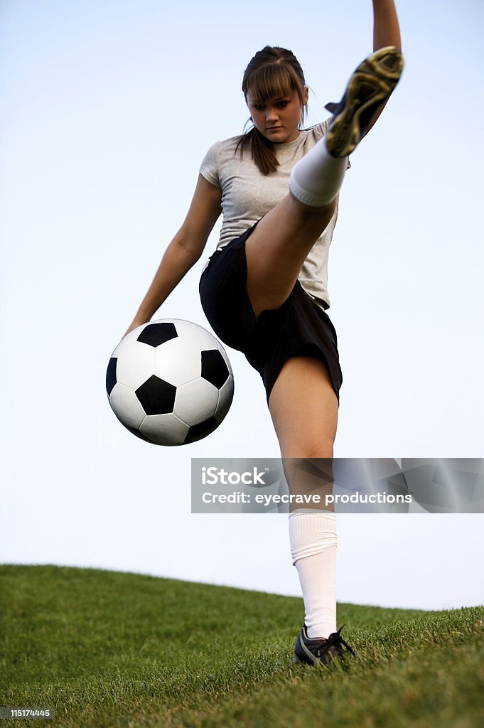 active teen female soccer portraits young teen girl kicking soccer ball out on a grassy field in uniform gear Soccer Player Stock Photo