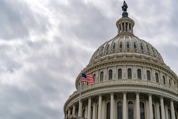 istock Washington DC Capitol with waving flag on sky background 1151746770