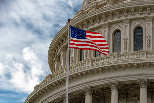 istock Washington DC Capitol with waving flag on sky background 1151746775