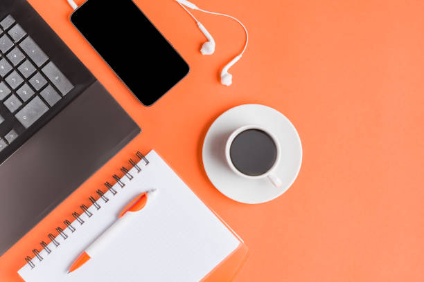 istock Creative concept. Work Desk, freelancer, businessman, student. Notebook, workbook, smartphone, pen, headphones on coral background, flat lay. 1151748609