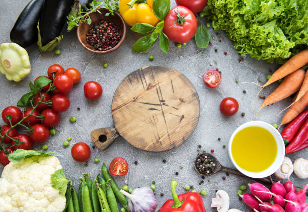 istock Empty board and fresh vegetables on a concrete background 1151749522