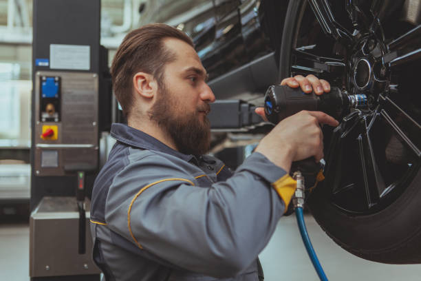 pracownik serwisu samochodowego naprawia samochody - lug nuts zdjęcia i obrazy z banku zdjęć