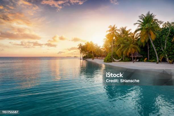 Sunrise Behind A Tropical Island In The Maldives Stock Photo - Download Image Now - Beach, Maldives, Tropical Climate