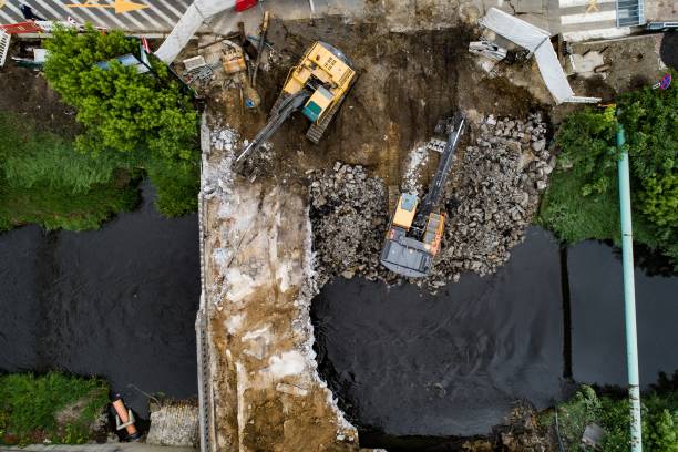 istock Drone view on excavators demolishing a road bridge. 1151757412