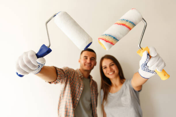istock Painters Painting a Wall with a Paint Roller. Selective focus on paint rollers 1151766032