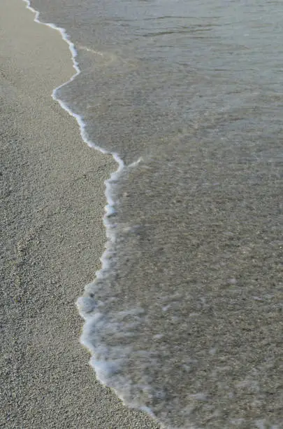 Sand gently rolling ashore on the beach.