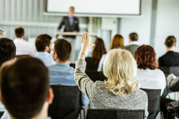 istock Back view of businesswoman asking a question on training class in a board room. 1151767273