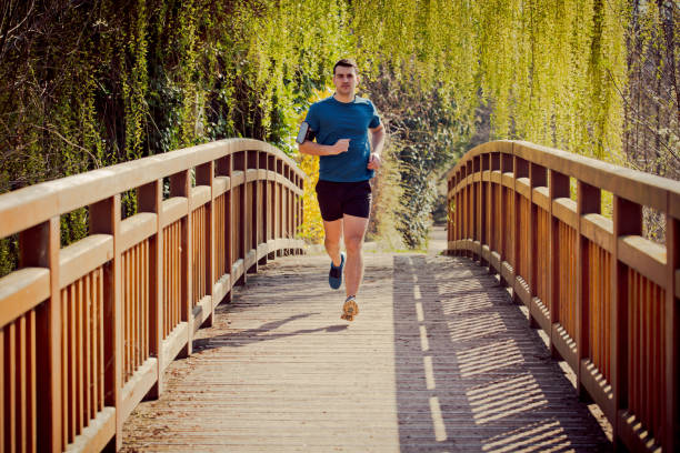 istock Male runner running in a city park over a bridge training 1151768851