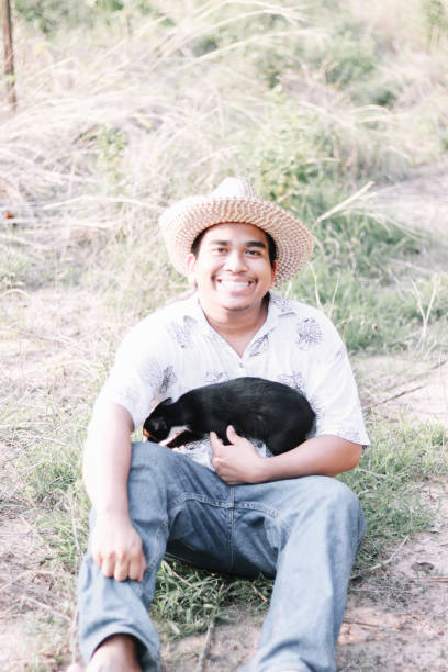 istock happy farmer playing with his cat 1151771658