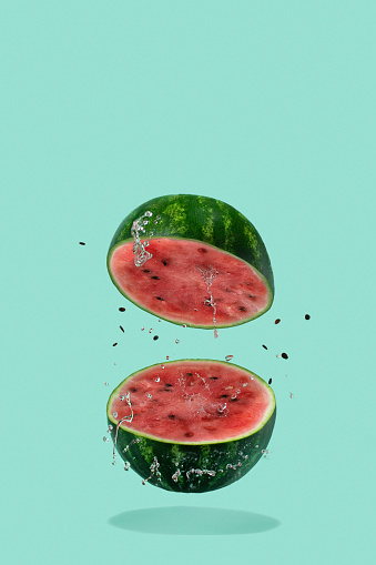 Watermelon sliced flying on pastel green background. Minimal fruit and summer concept.