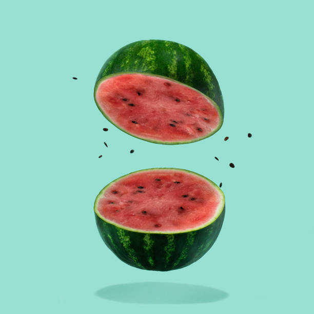 Watermelon sliced flying on pastel green background. Minimal fruit and summer concept. stock photo