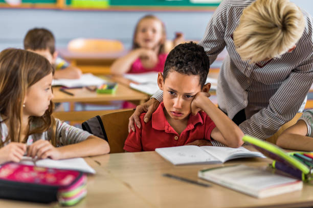 istock Female teacher consoling crying black student in the classroom. 1151773020