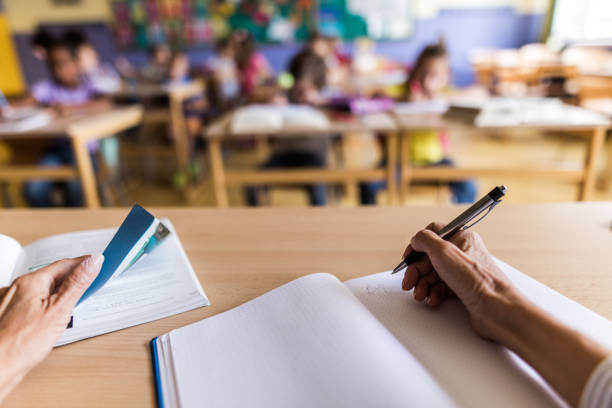 istock Close up of unrecognizable teacher taking notes on a class. 1151773673