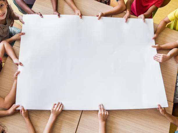istock Above view of unrecognizable elementary students with blank paper in the classroom. 1151774959