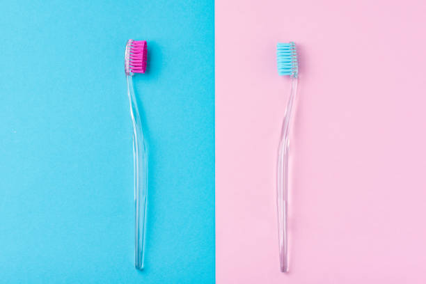 istock Two plastic toothbrushes on a pastel blue and pink  background, flat lay style 1151775842
