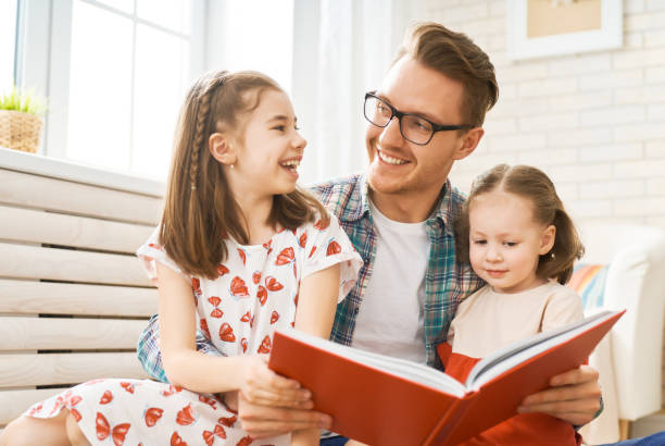 istock father reading a book to his daughters 1151776779