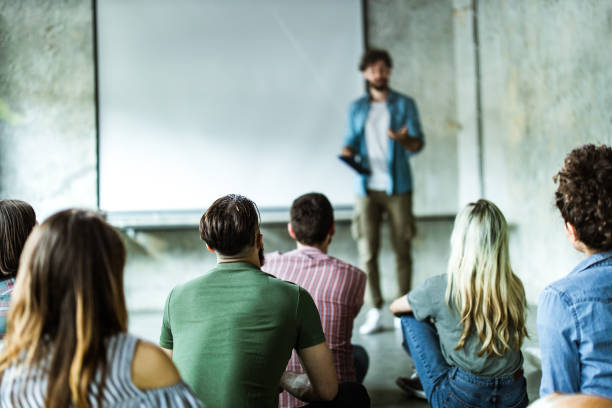 istock Rear view of creative people having an education event at casual office. 1151777009