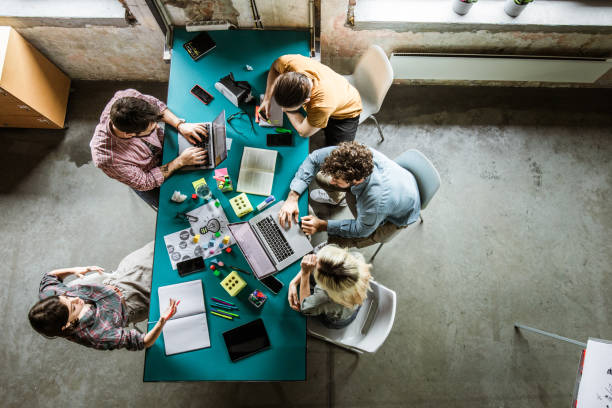 istock Above view of multi-tasking creative team working in the office. 1151777742