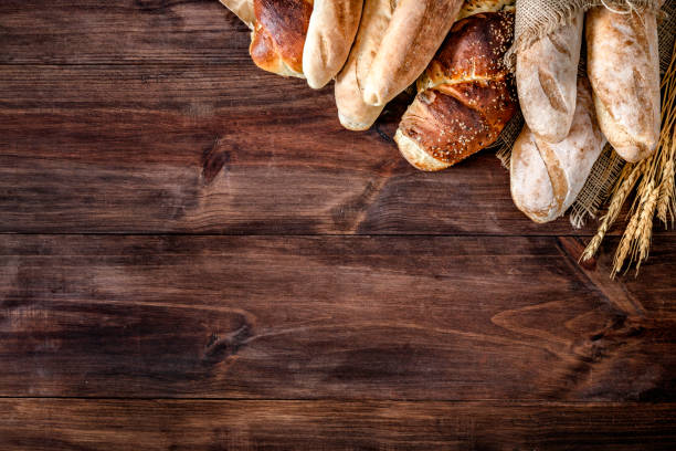 artisanal bakery:  fresh mixed bun, rolls and ingredients making a frame with copy space - pão fresco imagens e fotografias de stock