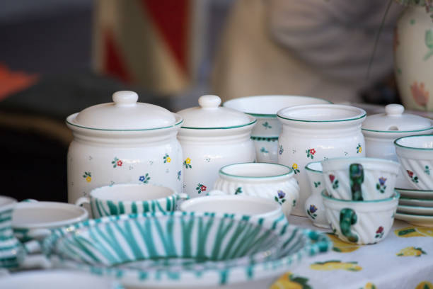 Crockery and dishes on a flea market, people in the blurry background
