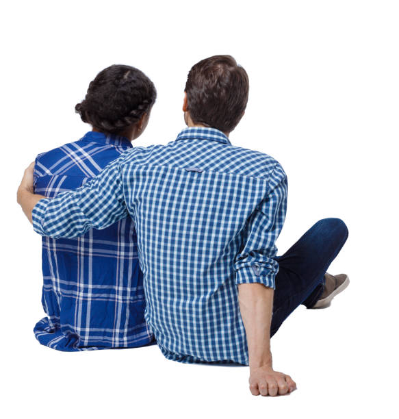 Back view of a multiethnic young couple sitting on the ground and hugging. Back view of a multiethnic young couple sitting on the ground and hugging. Rear view people collection.  backside view of person.  Isolated over white background. man touching womans buttock stock pictures, royalty-free photos & images