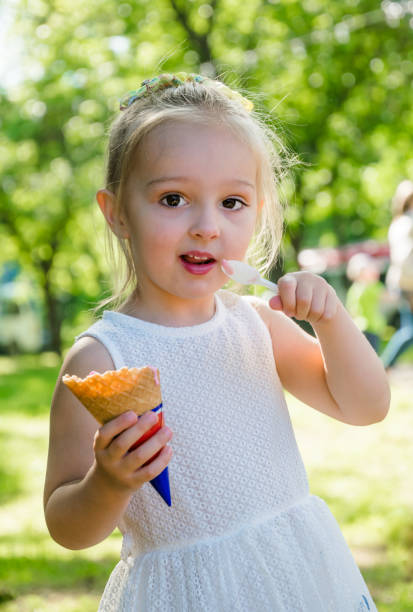 istock Funny little girl eats strawberry ice cream 1151783292