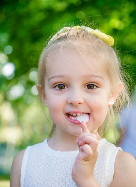 istock Funny little girl eats strawberry ice cream 1151783312