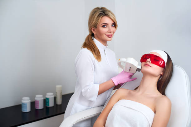 docteur esthéticienne faisant le rajeunissement rf de laser pour le visage assez jeune de femme au salon de beauté. procédure d’épilation de l’épilation elos. soin esthétique du visage acné traitement soins de la peau. hardware ipl cosmétologie - massage therapist massaging sport beautician photos et images de collection