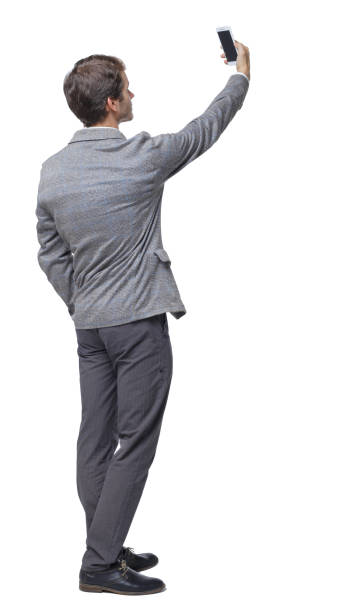 istock Back view of a businessman in a suit making a selfie. 1151784451
