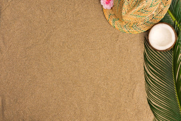 istock Space for text, beach theme on the sand background. Hat, coconut  on  the sand background. Top view. 1151787022
