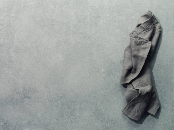 Gray linen napkin on gray stone, copy space