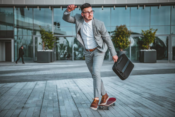 istock Stylish manager riding a skateboard in city 1151788129