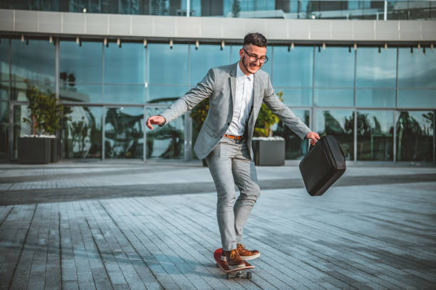 istock Stylish manager riding a skateboard in city 1151788220