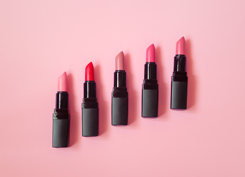 Set of beautiful lipsticks on pink background.